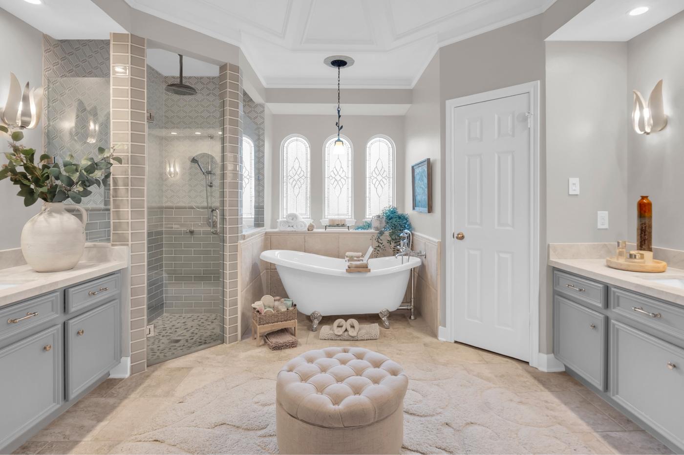 Primary bathroom with a freestanding tub and arched windows