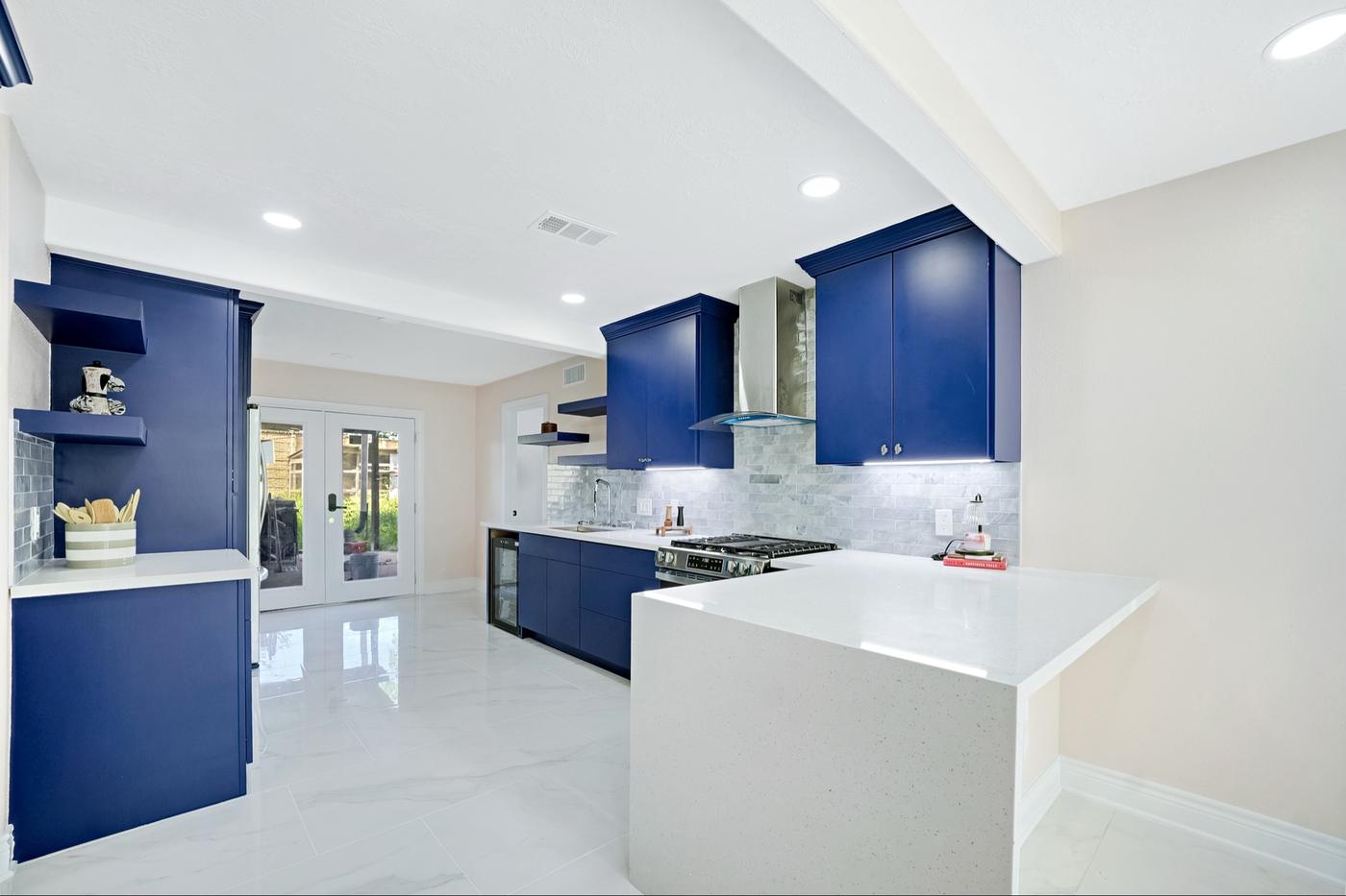 Open kitchen with navy cabinets and a white island