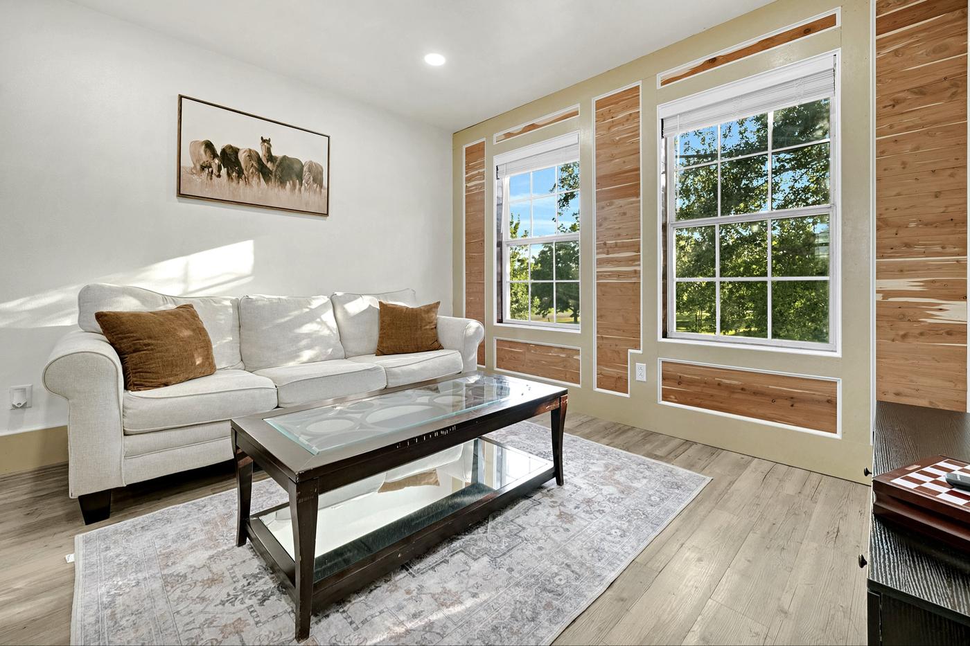 Living room with tall windows and a wood accent wall